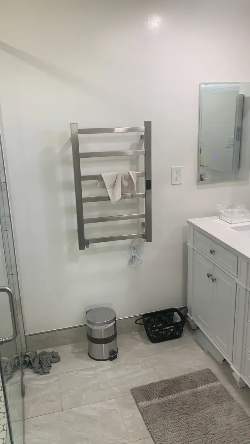 Modern Woodland Hills bathroom with a wall-mounted heated towel rack beside a white vanity.