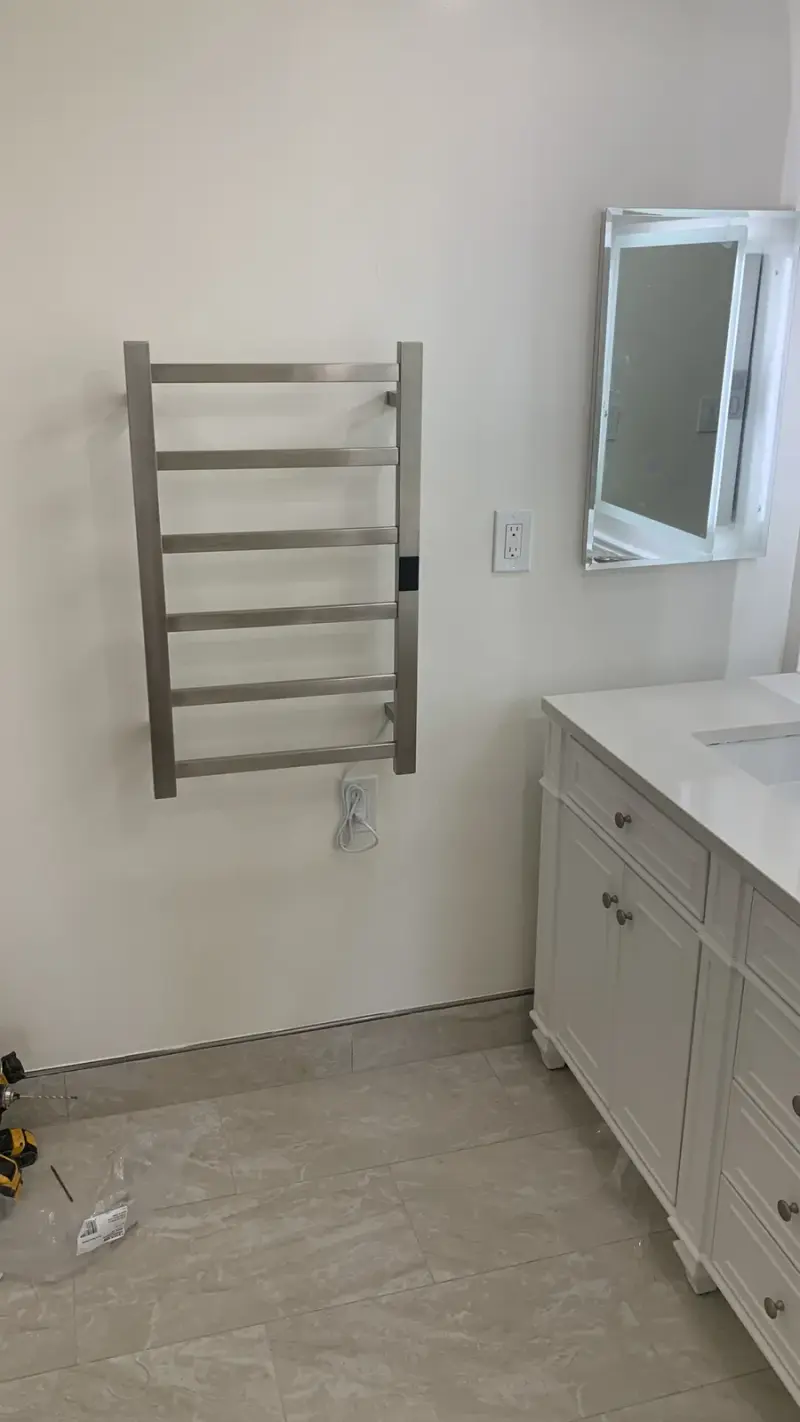 Chrome wall-mounted towel warmer in a modern Woodland Hills bathroom remodel.
