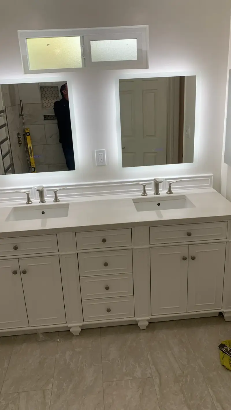White double vanity with backlit LED mirrors in a Woodland Hills spa bathroom remodel.