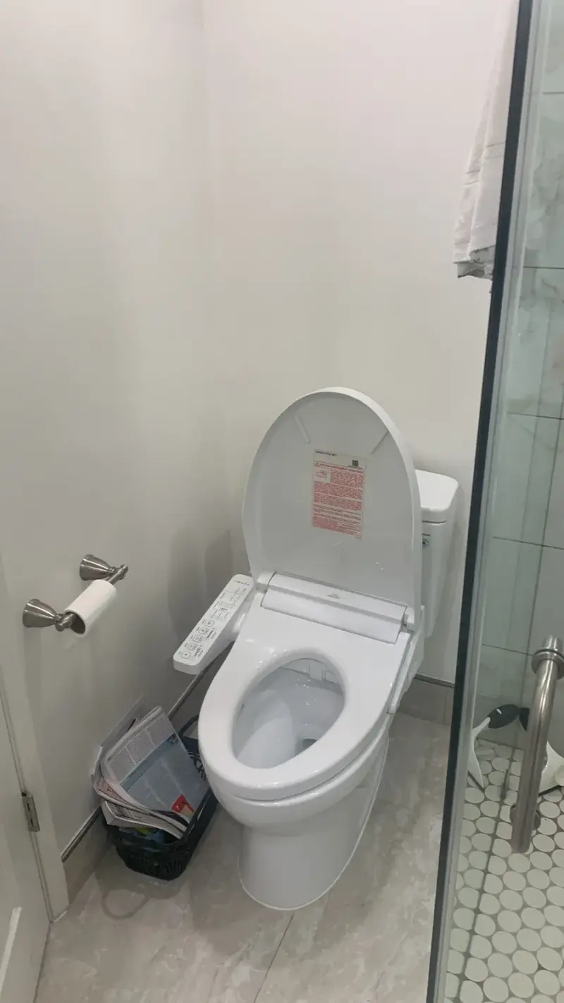 Modern white toilet with an electronic bidet seat in a Woodland Hills bathroom remodel.